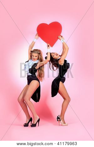 İki seksi playgirls kostümleri pussycat ve bir fare pembe bir arka plan üzerinde kırmızı kalpli çekici.