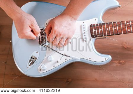 Guitar Master Restringing Electric Guitar, Top View, Closeup