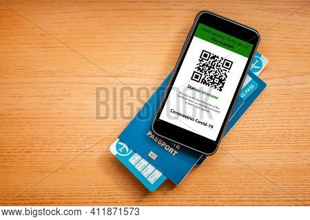passport and a smart phone with a digital of a certificate of vaccination against the Covid-19 disease.