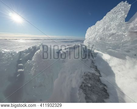 Ice Slopes In Sunny Winter Day, Transparent Ice Of Blue Color, Purely Blue Sky, Long Shadows, A Pure