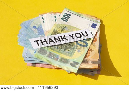 Various Denominations Of Euro Banknotes And The Words Thank You Isolated On Yellow Background