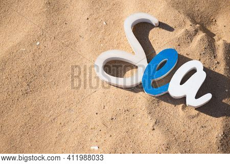 Decorative Sea Inscription, Woodenl Letters Against The Backdrop Of Beach Sand Summer Vacation Conce