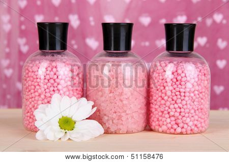 Aromatherapy minerals - colorful bath salt on pink background