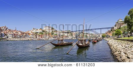 The iconic Rabelo Boats, the traditional Port Wine transports, with the Ribeira District and the Dom Luis I Bridge over the Douro River. Porto, Portugal. Unesco World Heritage.