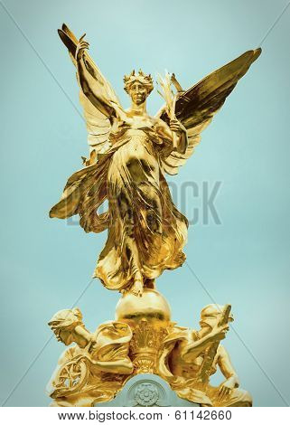 Gold statues on top of the Queen Victoria Memorial in London, cross processed effect