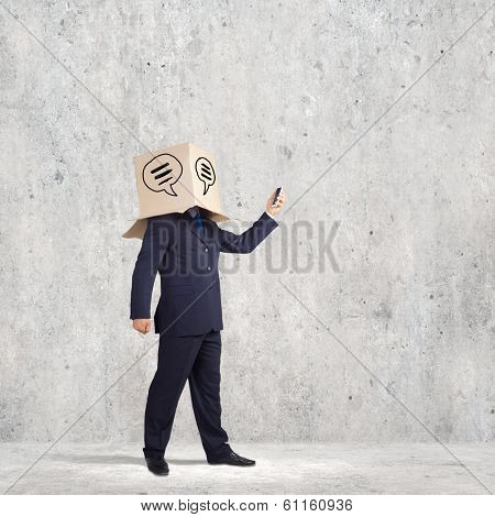 Businessman using mobile phone wearing carton box on head
