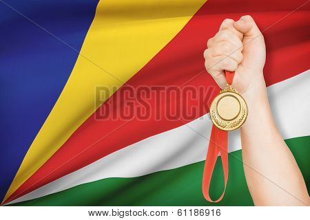 Medal In Hand With Flag On Background - Republic Of Seychelles