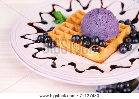 Tasty belgian waffles with ice cream on wooden table