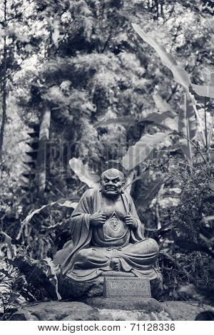 Old ruined Arhat Kanakbharadvaja statue in forest, Taiwan, Asia.