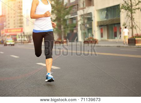 Runner athlete running on city road. woman fitness jogging workout wellness concept.