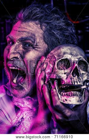 Close-up portrait of an old medieval scientist holding a skull. Alchemist. Halloween.