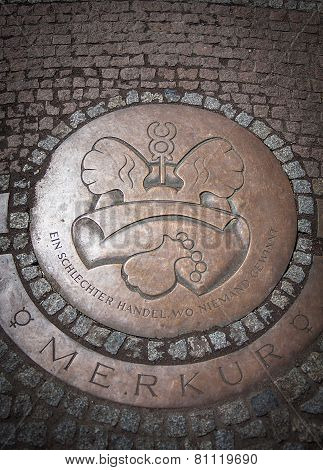Round Iron hatch for sewer on cobblestone pavement