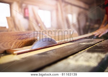Carpenter sawing wooden planks