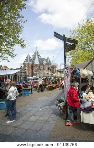 Tourists Reading A Map Near Market Stall On Nieuwmarkt In Amsterdam