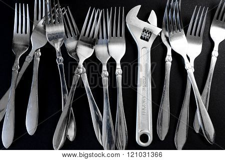 Set of forks, and wrench on a black background