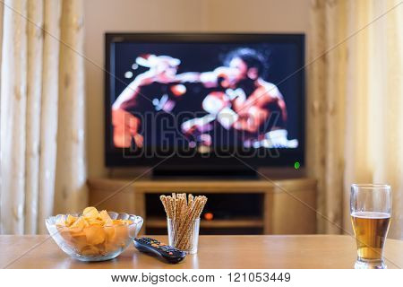 Television, Tv Watching (boxing Match) With Snacks And Alcohol Lying On Table - Stock Photo