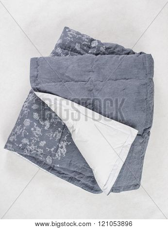 Dark Gray Duvet With White Underside Exposed Over White Backdrop