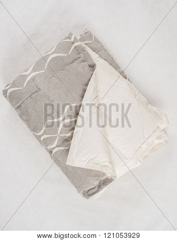 A Folded Gray Duvet With White Concave Line Pattern