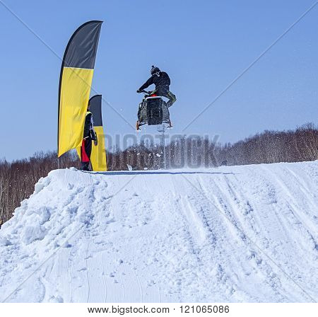 Snowmobile on the route in a jump in air in Kamchatka