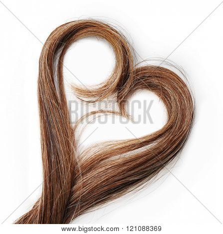 Strands of brown hair in shape of heart, isolated on white