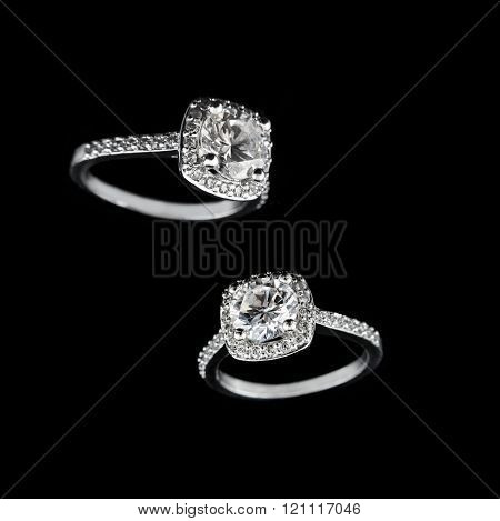 Luxury jewellery. White gold or silver engagement rings with diamonds closeup on black background. S