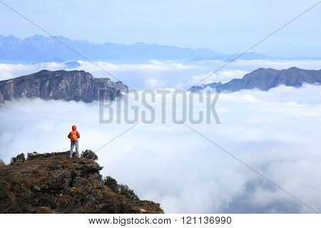 young woman backpacker hiking at mountain peak