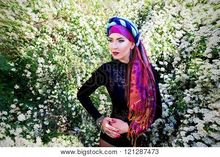 portrait of the beautiful girl in a turban on the flowers of spirea background