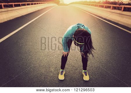 tired woman runner taking a rest after running hard on city road