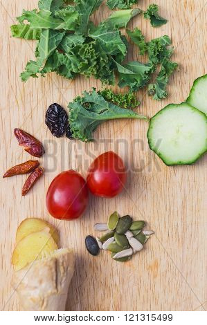 Ingredients of a healthy green juice smoothie: fresh ginger avocado tomatoes seeds and kale
** Note: Shallow depth of field