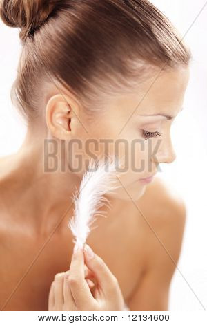 Belle femelle toucher plume à sa peau propre sain closeup over white