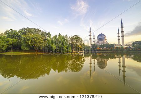 SELANGOR MALAYSIA - JANUARY 30 2016: The Beautiful Sultan Salahuddin Abdul Aziz Shah Mosque (also known as the Blue Mosque) with nature sunrise lighting and reflection.