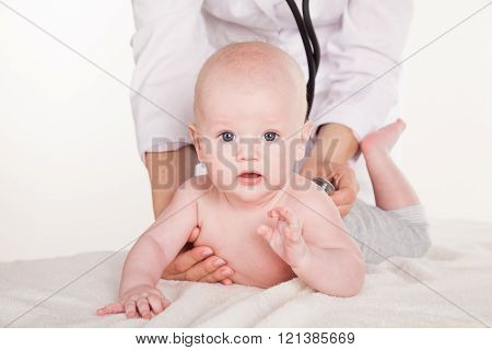 the doctor listens to the baby newborn