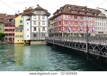 LUCERNE, SWITZERLAND- JUNE 13, 2015: The historic medieval houses along the Reussteg with Chateau Gutsch. Many fine historic houses decorated with frescoes line the picturesque town squares.