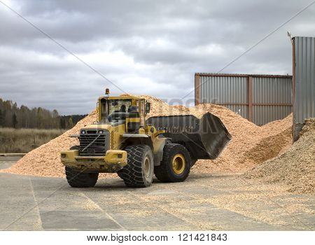Front Loader By The Pile Of Sawdust