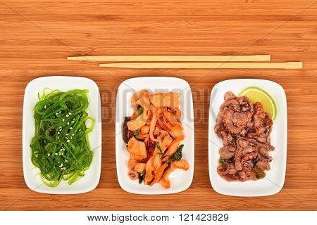 Three Seafood Salads With Chopsticks On Wood