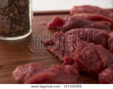 cooking a meat dish. Meat and a meat cleaver on a chopping board