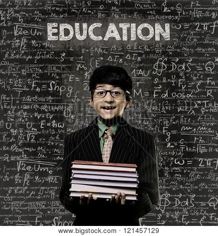 Education. Genius Little Boy Holding Book Wearing Glasses Chalkboard
