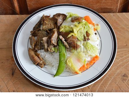 fried pork entrails with garlic and stir-fried mixed vegetable on rice