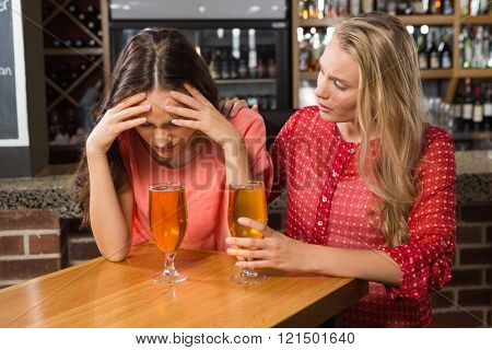 Cute friends having a glass of beer in a pub