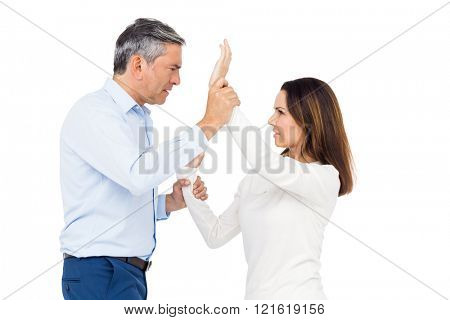 Violent man grabbing wifes wrists against white background