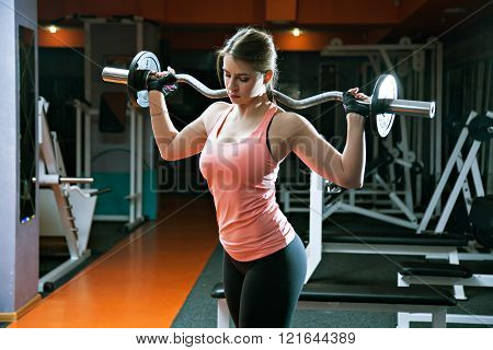 Portrait Of Serious Athlete Girl Holds Metal Barbell