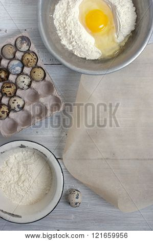 Ingredients for the pancakes on the white wooden table around the parchment roll