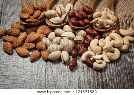Healthy mix nuts on wooden background. Almonds, hazelnuts, cashews, peanuts