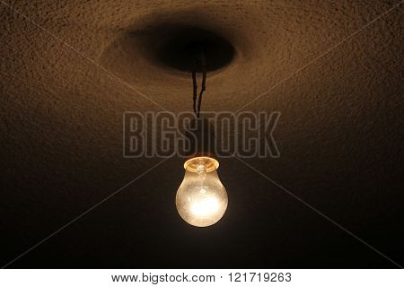 A cable hanging bulb in a dark room.