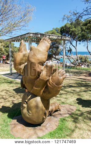 COTTESLOE,WA,AUSTRALIA-MARCH 12,2016: Figure standing on head with pig sculpture at the 