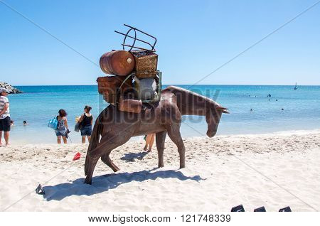 COTTESLOE,WA,AUSTRALIA-MARCH 12,2016:  Horse with a large load sculpture with tourists at the interactive free public arts festival 