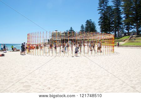 COTTESLOE,WA,AUSTRALIA-MARCH 12,2016:  Circular pole and ribbon sculpture with people at the interactive arts festival 
