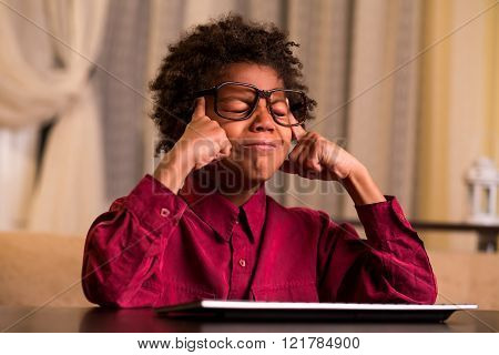 Upset black boy at keyboard.