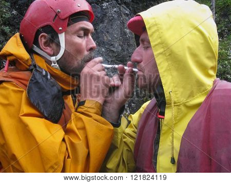 LUTSK UKRAINE - AUGUST 09 - Two men wearing helmet lights smoking cigarette near rock in Lutsk on August 09 2008.