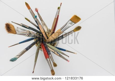 Photo of artist paint brushes in a jar. Top view with copy space.
